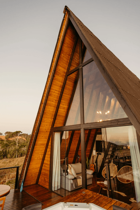 Real A-frame holiday home with timber cladding, full-height glass and an entrance from the deck