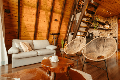 Cream sofa, woven chairs and live-edge coffee table in the same timber holiday home