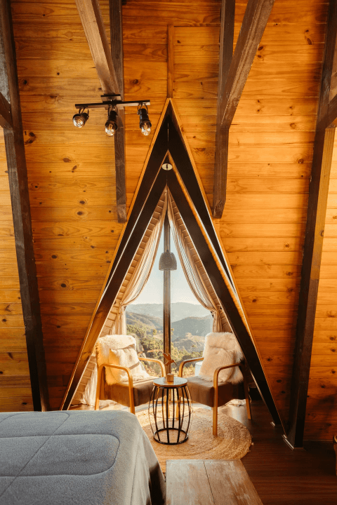 Loft sitting area with two armchairs beside a triangular window