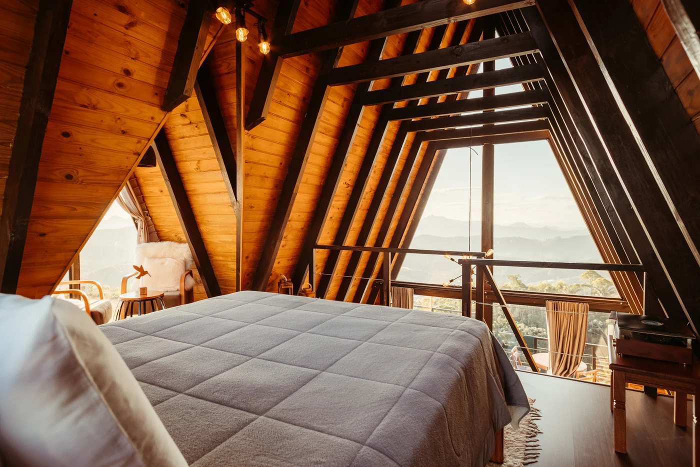 Loft bed beside the sitting nook and railing overlooking the living room